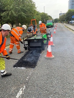 Workers carrying out thermal road repairs