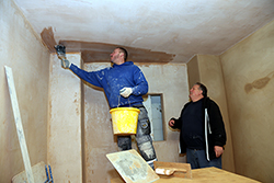 2 people plastering a ceiling