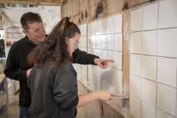 student learning to tile a wall