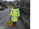 school crossing patrol person holding sign upside down