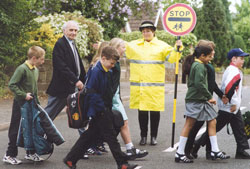 Crossing patrol person helping pedestrians across road