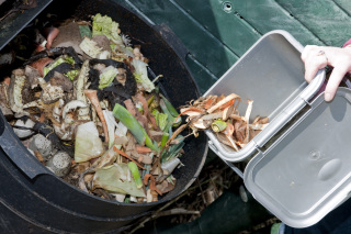 food waste being poured into a compost bin