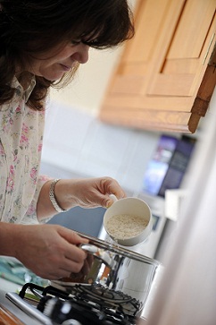 Woman pouring porridge into a boiling pan