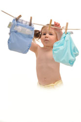 Young child hanging real nappies on a washing line