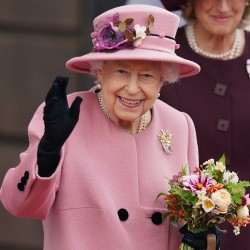 The Queen holding a bouquet and waving