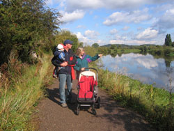 Family walking on a path by water