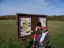 People looking at an information board on the Five Pits Trail