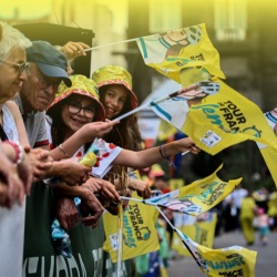 Spectators waving flags and cheering on the riders