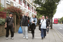 group of people walking in the street with shopping