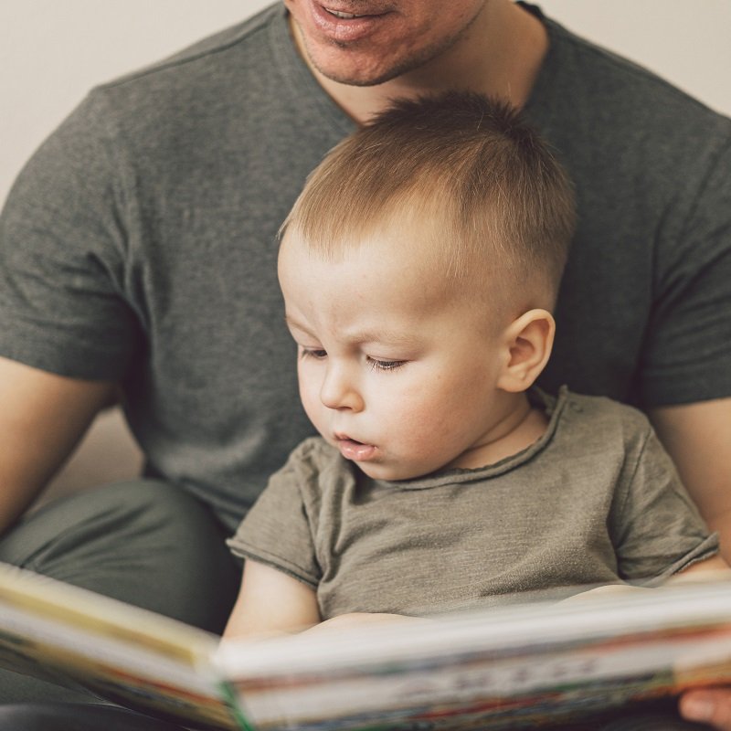 Father reading a book to his son