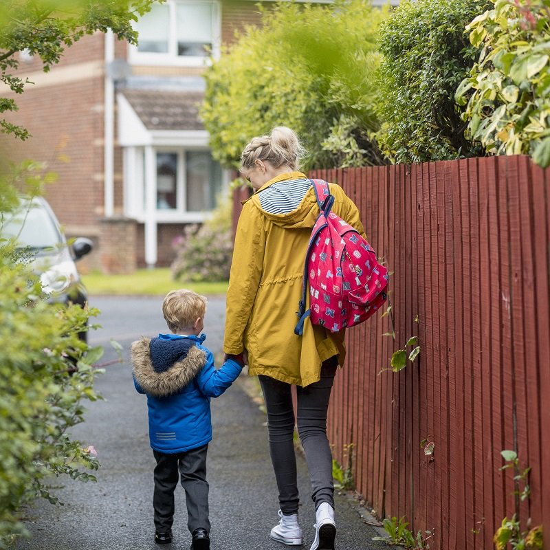 Mother and son walking down the street holding hands
