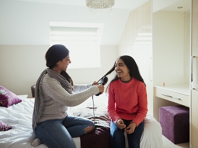 Mother brushing her daughters hair