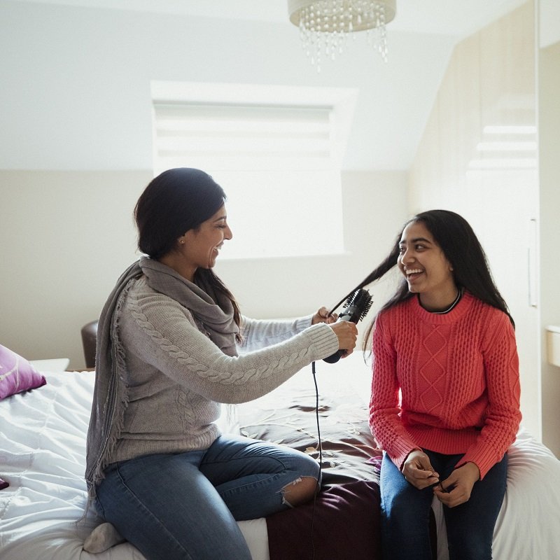 Mother brushing her daughters hair