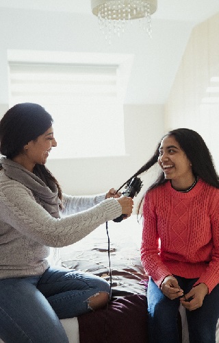 Mother brushing her daughters hair