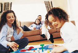 Parents watch their children play board games in the lounge